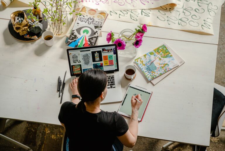 Value Graphic Design: Tips and Examples for Maximizing ROI 8 photo of woman writing on tablet computer while using laptop