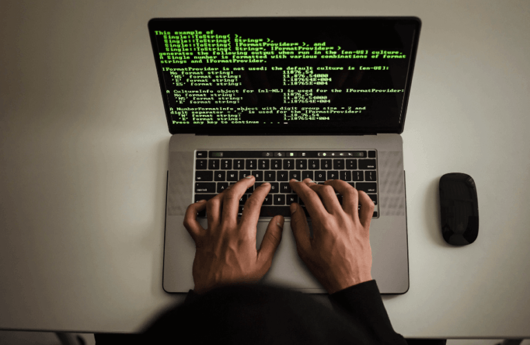 A programmer coding on a laptop