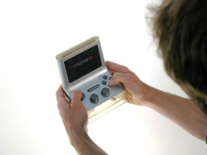 Holding A MOMA Mobile Gaming Console (2290536922) - a man holding a cell phone