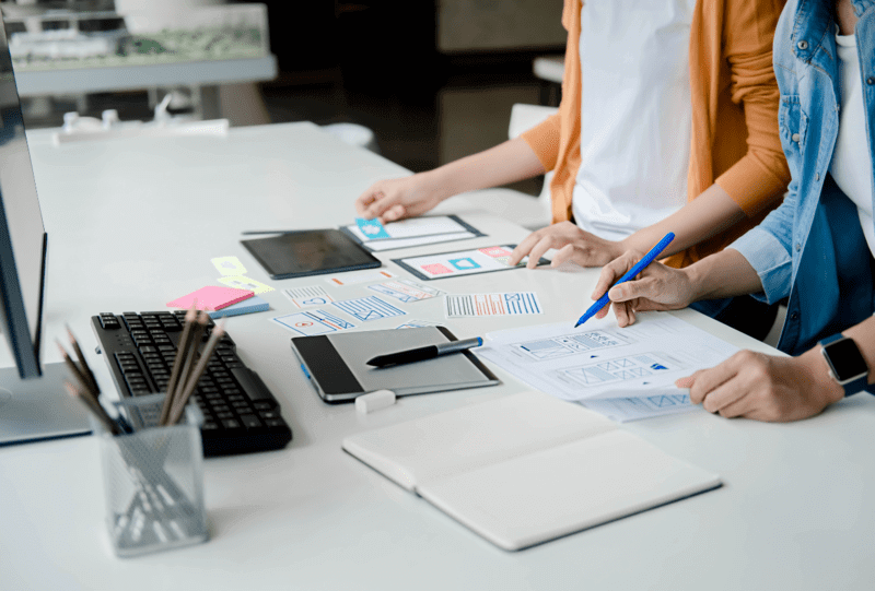 Tripleshdaes | ui-ux-design, employees at the office with designing tools on a desk